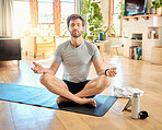 One young caucasian man sitting with legs crossed and eyes closed meditating in harmony with om finger gesture while practising yoga at home. Calm, relaxed and focused guy feeling zen while praying quietly for stress relief and peace of mind