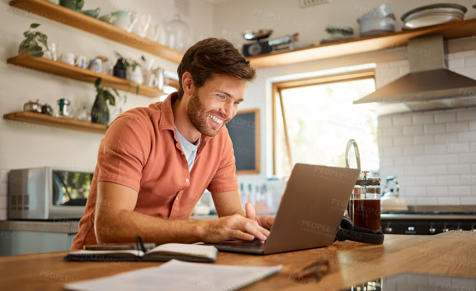 Buy stock photo Smile, laptop and remote work, happy man at kitchen counter with app for email, social media or networking for online job. Technology, communication and freelancer on internet writing blog or article