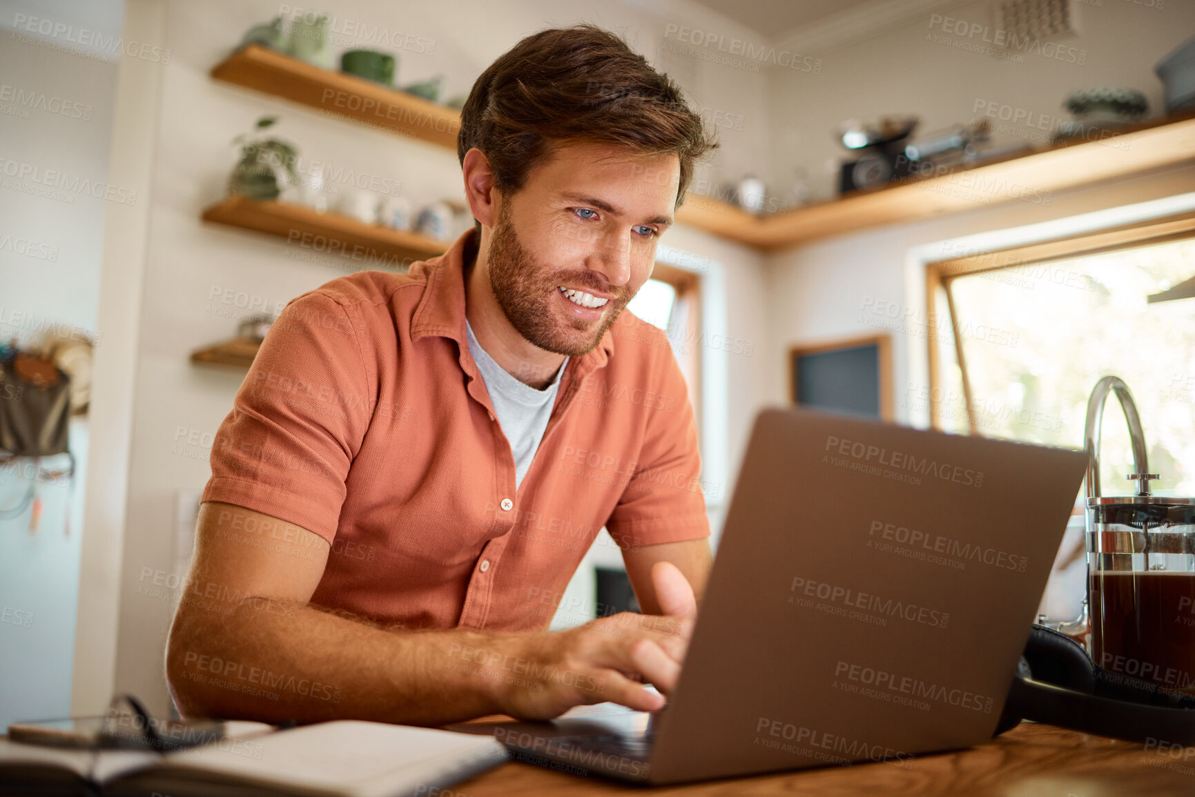 Buy stock photo Networking, laptop and remote work, happy man at kitchen counter with email, social media post or research for job. Technology, writer or freelancer on internet typing blog or online article at home.