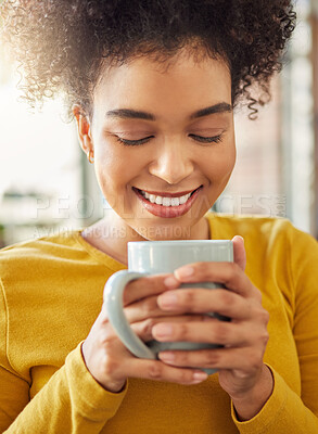 Young cheerful mixed race woman holding and drinking a cup of coffee at home. One comfy hispanic female enjoying a cup of tea while relaxing at home