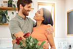 Young caucasian boyfriend giving his mixed race girlfriend a bouquet of flowers at home. Hispanic wife receiving roses from her husband. Interracial couple bonding together at home