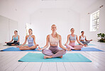 Group of women in yoga class together. Group of women sitting in lotus pose in yoga practice. Tranquil women sitting on yoga mats in a class. Women practicing yoga posture in a studio