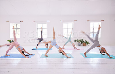 Buy stock photo Group of women in downward dog pose. Young women in downward dog with a leg stretched. Dedicated women stretching together in a pilates class. Group of women practice yoga routine together