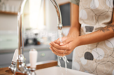 Buy stock photo Close up of woman washing her hands in sink with tap water in the kitchen at home. Always wash your hands before cooking