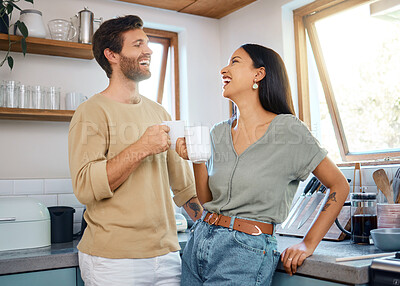 Buy stock photo Loving young interracial couple drinking their morning coffee and talking while standing in the kitchen at home. Young man and woman looking happy to be together in healthy relationship