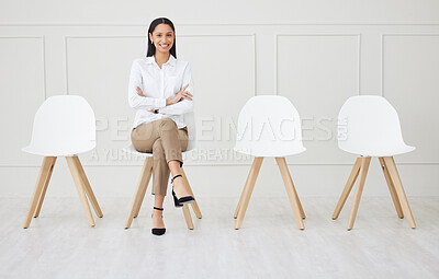 Buy stock photo Full length of mixed race businesswoman waiting for an interview. One young applicant sitting alone. Professional candidate with arms folded in line for job opening, vacancy and opportunity in office