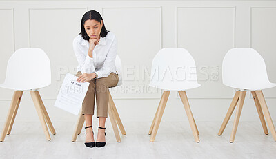 Full length of mixed race businesswoman waiting for interview. One young stressed applicant sitting alone. Sad ethnic professional holding resume in line for job opening, vacancy, office opportunity