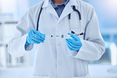 Buy stock photo doctor wearing a labcoat and gloves preparing a covid vaccine while working in a hospital. Unrecognizable scientist removing liquid from a vial using a syringe while working at a lab
