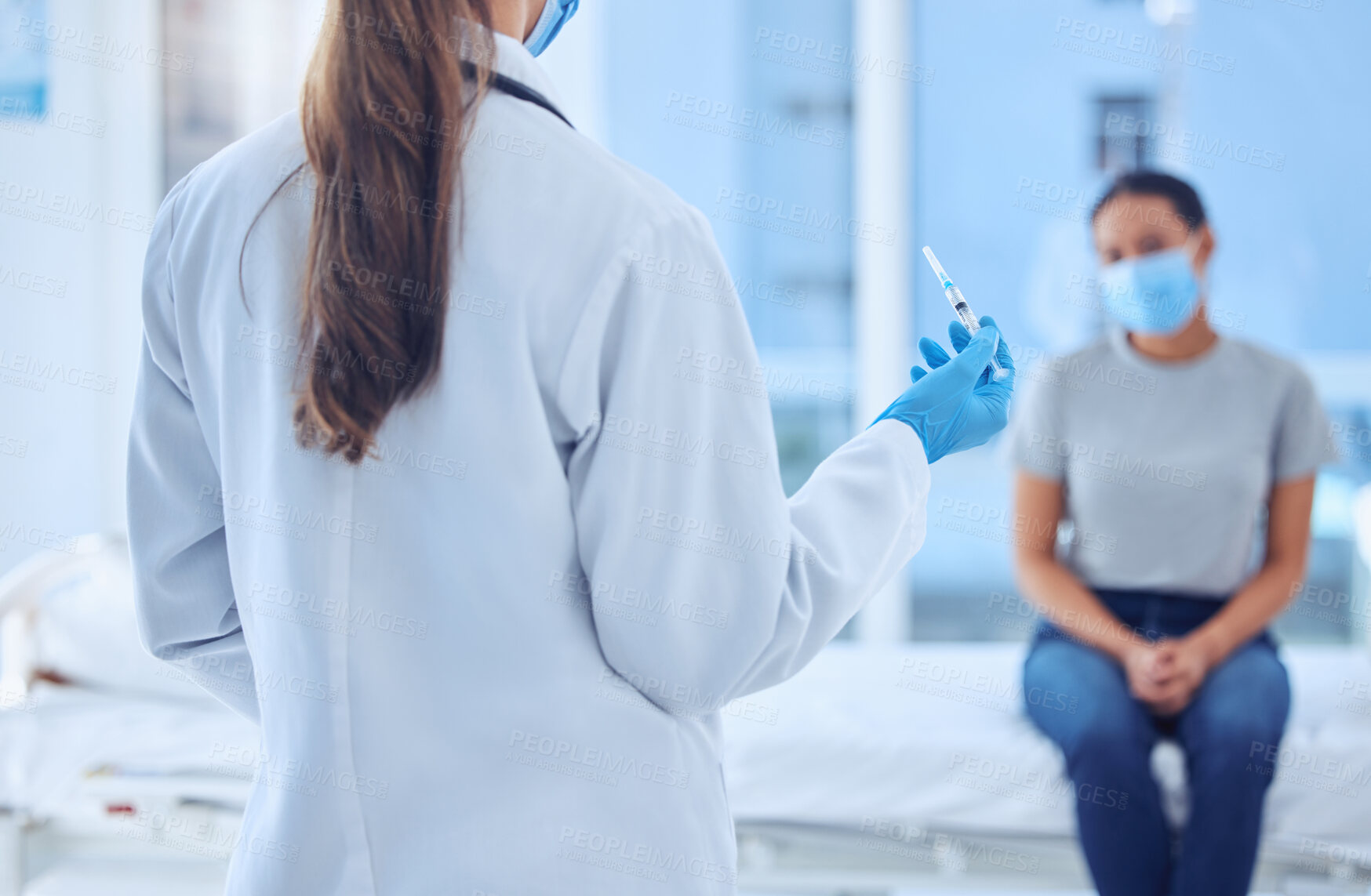 Buy stock photo Doctor holding a needle in a consult. Back of physician about to inject patient in consult. patient about get covid vaccine. Doctor holding syringe corona virus cure. Patient in consult with doctor