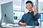 Portrait of one happy hispanic call centre telemarketing agent talking on a headset while working on a computer in an office. Confident friendly male consultant operating a helpdesk for customer service and sales support