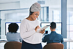 Young african american businesswoman browsing on a digital tablet device while working in a call centre with her colleagues in the background. Happy manager and supervisor planning online with smart apps for customer service support