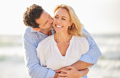 Closeup of an mature affectionate caucasian couple standing on the beach and smiling during sunset outdoors. Caucasian couple showing love and affection on a romantic date at the beach