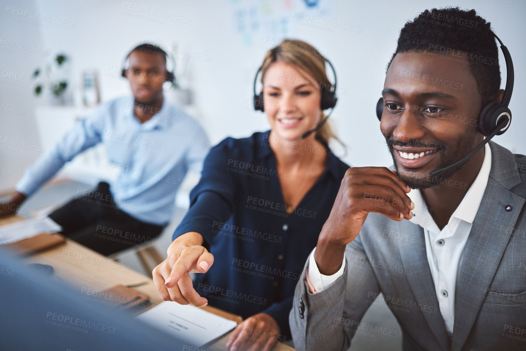 Buy stock photo Happy african american male call centre telemarketing agent discussing plans with diverse colleagues while working together on computer in an office. Consultants troubleshooting solution for customer service and sales support