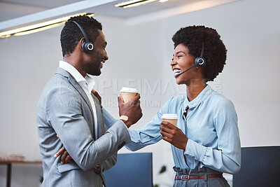 Buy stock photo Two happy young african american call centre telemarketing agents having a chat while drinking coffee and laughing together during lunch break in an office