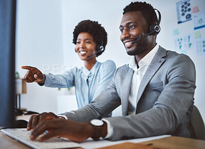 Buy stock photo Happy african american male call centre telemarketing agent discussing plans with colleague while working together on computer in an office. Two consultants troubleshooting solution for customer service and sales support