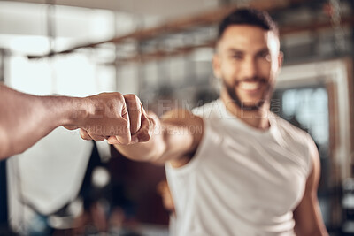 Buy stock photo Two athletes giving each other a fist bump. bodybuilders celebrate during a workout in the gym. Happy fit men motivate each other to exercise. hands of athletes join in the gym to fist bump