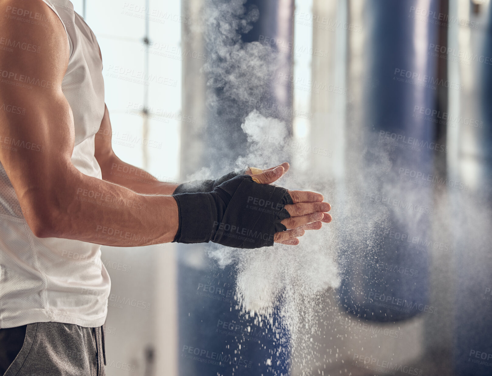 Buy stock photo Mma fighter prepare for boxing routine. Combat using chalk to prepare for training workout. Boxer getting ready with dust for combat workout. Athlete using dust on their hands cropped in the gym