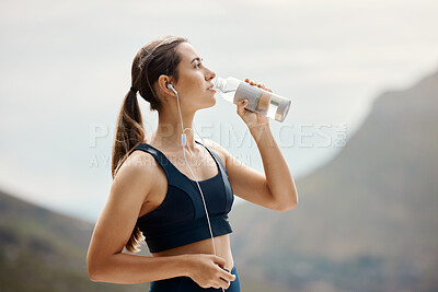 Buy stock photo Fitness, woman with earphones, drinking water and hiking in nature for health and wellness during exercise. Music, bottle and fit girl on hike in park for body workout with radio streaming or podcast
