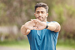 Closeup of hands of one fit young indian man stretching arms for warmup to prevent injury while exercising outdoors. Male athlete preparing body and muscles for training workout or run at the park