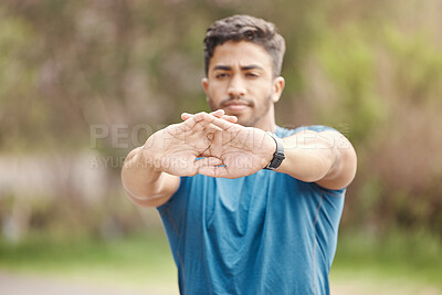 Buy stock photo Closeup of hands of one fit young indian man stretching arms for warmup to prevent injury while exercising outdoors. Male athlete preparing body and muscles for training workout or run at the park