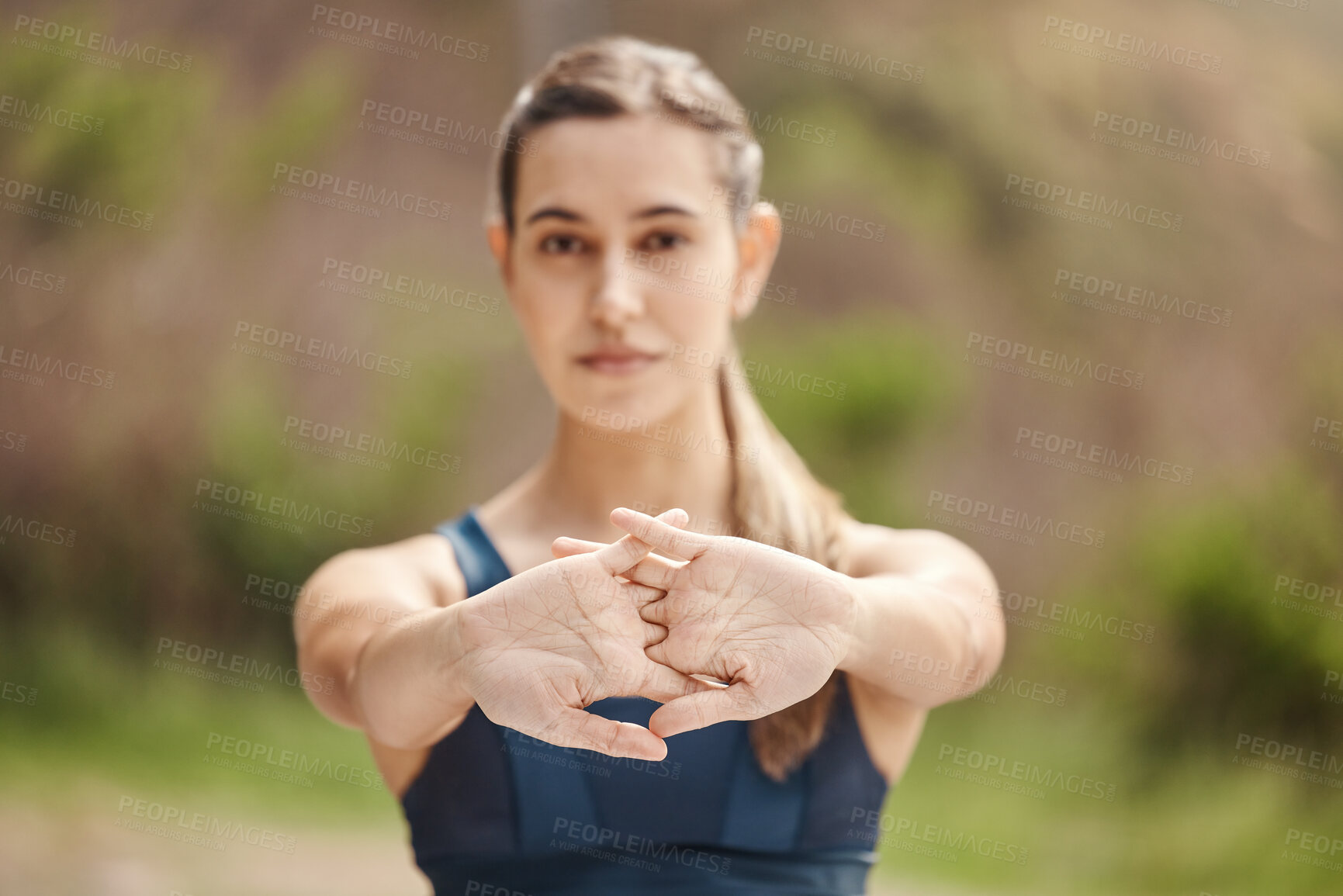 Buy stock photo Closeup of hands of one fit young mixed race woman stretching arms for warmup to prevent injury while exercising outdoors. Female athlete preparing body and muscles for training workout or run at the park