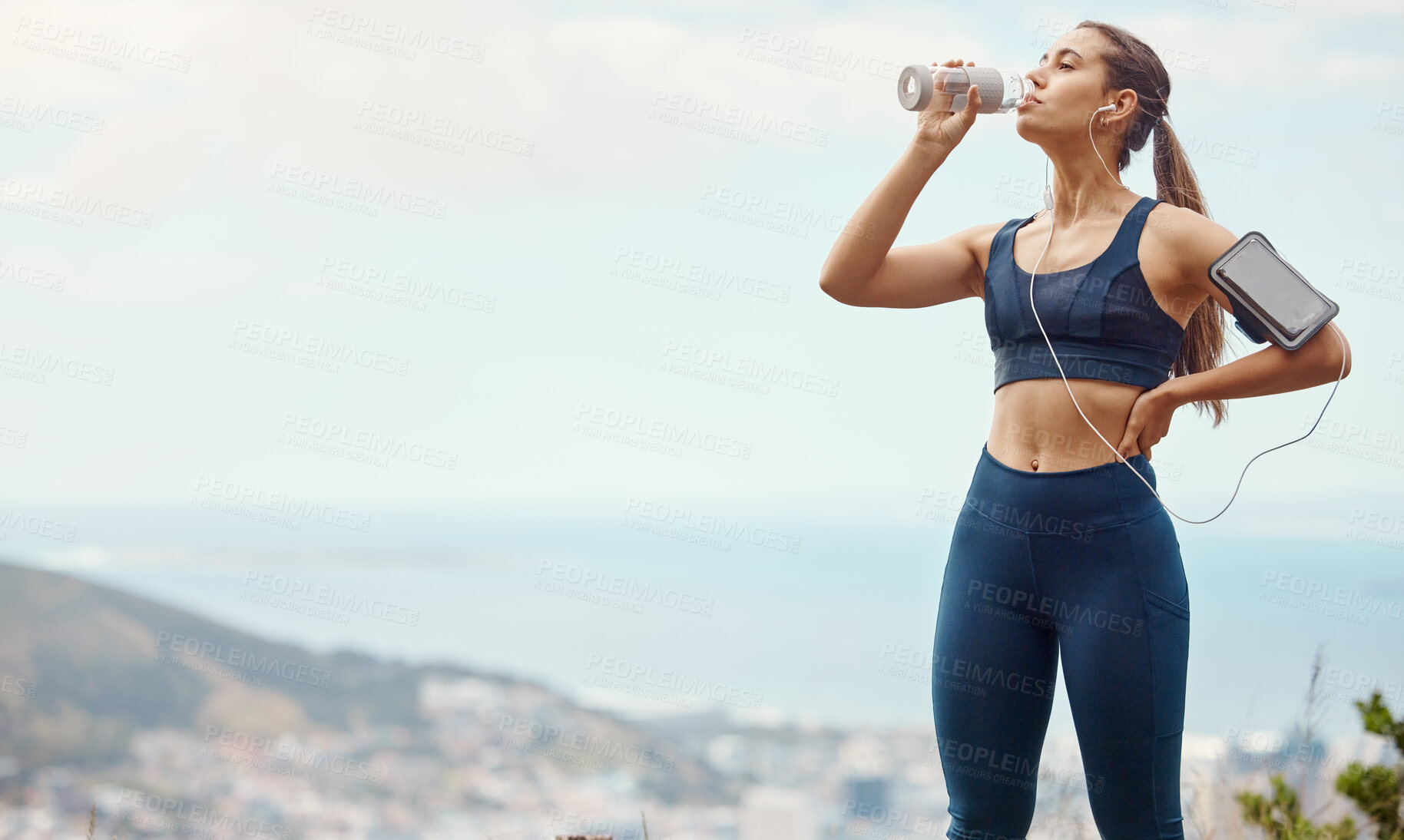 Buy stock photo Fitness, relax, woman with drinking water and hiking in nature mockup for health and wellness during exercise. Music, bottle and fit girl on hike in park with phone, earphones and radio or podcast.