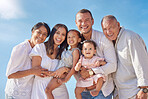 Portrait of smiling mixed race family with little girls standing  together on beach. Adorable little kids bonding with mother, father, grandmother and grandfather outside