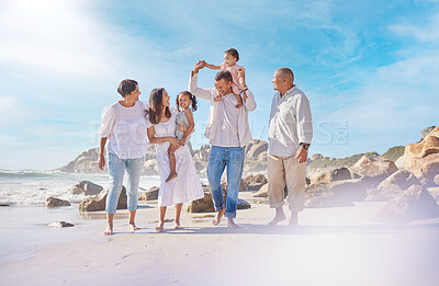 Buy stock photo A smiling mixed race three generation family with little girls walking together on a beach. Adorable little kids bonding with mother, father, grandmother and grandfather outside