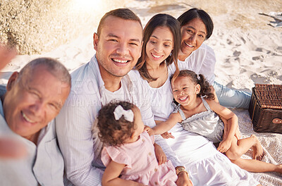 Buy stock photo Portrait of smiling mixed race family with little girls taking selfies together at the beach. Adorable little kids bonding with their parents and grandparents while having a picnic at a park or garden