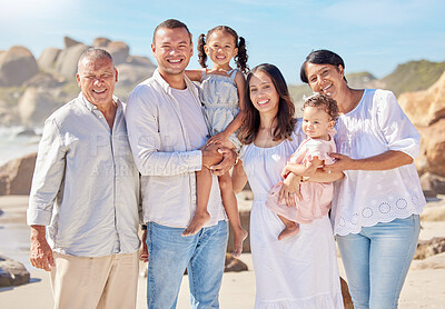 Buy stock photo Portrait of smiling mixed race family with little girls standing  together on beach. Adorable little kids bonding with mother, father, grandmother and grandfather outside