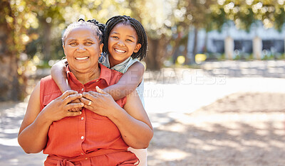 Portrait happy mature woman and her granddaughter spending quality time together in the park during summer. Cute little girl and her grandmother bonding outdoors. A granny and her grandchild smiling