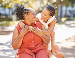 Happy mature woman and her adult daughter spending quality time together outside in the park during summer. Beautiful woman and her mother bonding outdoors. A senior lady and her adult child smiling