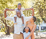 Portrait happy african american family of four spending quality time together in the park during summer. Mother, father, son and daughter bonding together outside. Cute siblings and parents outdoors