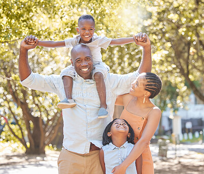 Portrait happy african american family of four spending quality time together in the park during summer. Mother, father, son and daughter bonding together outside. Cute siblings and parents outdoors