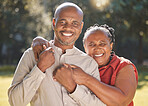 Portrait happy affectionate mature african american couple sharing an intimate moment outside at the park during summer. In love senior adults smiling while spending quality time together outdoors