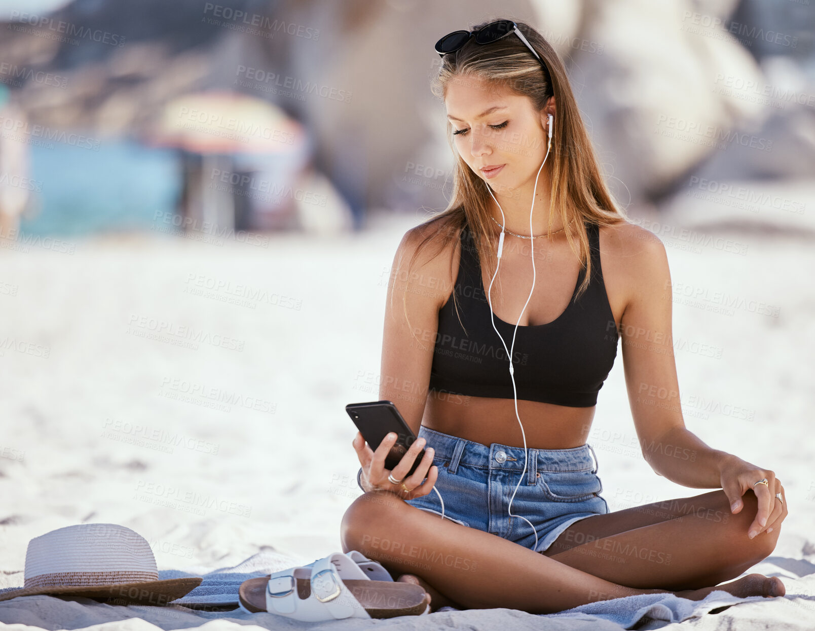 Buy stock photo Phone, music and a woman on the beach in summer to relax while on holiday or vacation by the ocean. Sand, nature and mobile with an attractive young female traveler sitting on the coast as a tourist