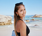 One beautiful young caucasian woman relaxing on the beach. Enjoying a summer vacation or holiday outdoors during summer. Taking time off and getting away from it all. Spending the day alone outside