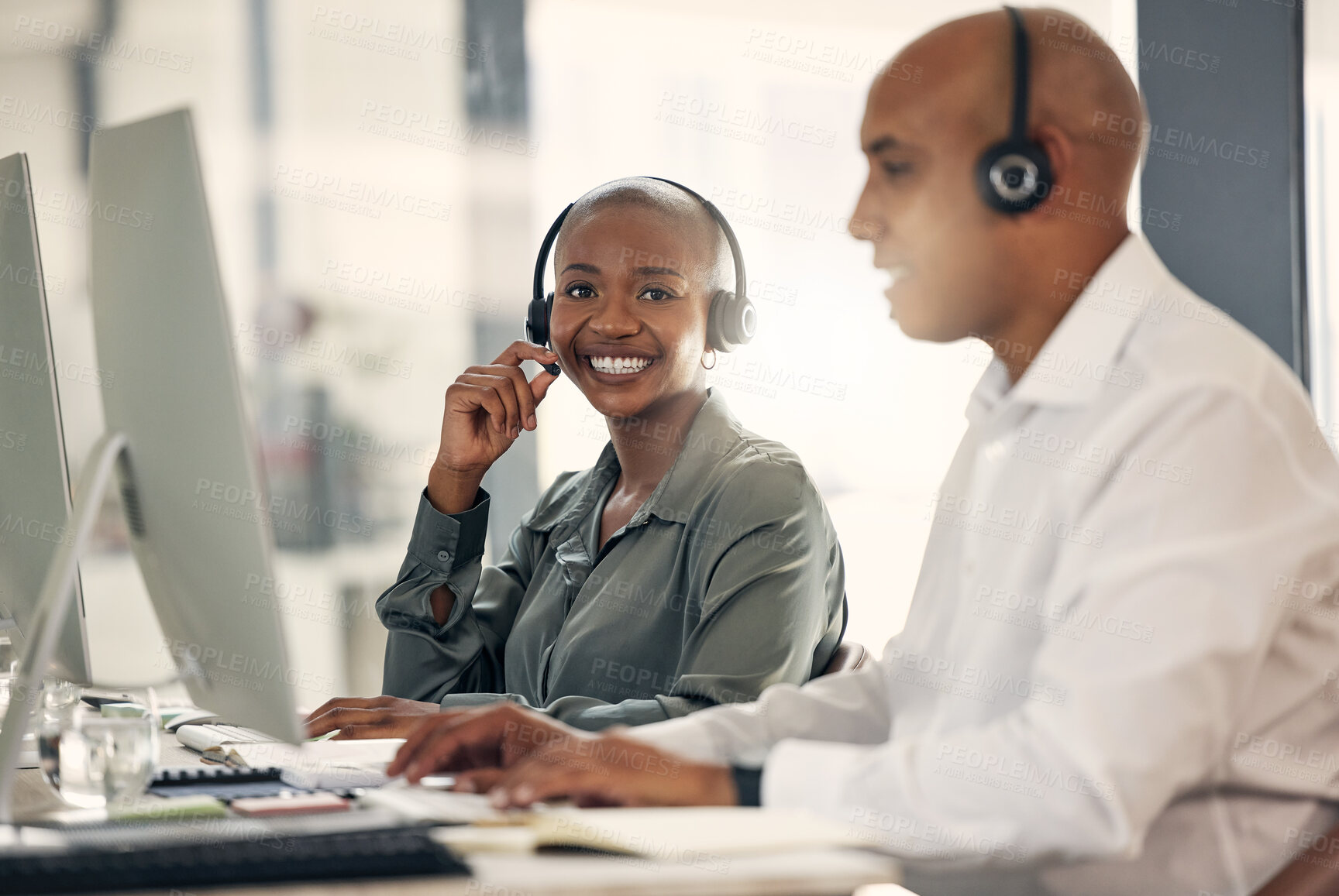 Buy stock photo Customer service, smile and a woman with a headset at computer for call center sales. African female and man or team in crm, telemarketing or help desk support and contact us solution or advice