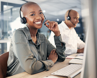 Buy stock photo Portrait of happy young african american call centre telemarketing agent talking on a headset while working on a computer in an office. Confident friendly female consultant operating helpdesk for customer service and sales support