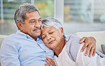Closeup of an affectionate mixed race senior couple relaxing in their living room at home. Hispanic man and wife  bonding on the sofa in the living room being affectionate