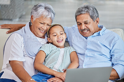 Buy stock photo Closeup of an affectionate mixed race senior couple relaxing in their living room with their granddaughter using a laptop. Hispanic man and wife  bonding on the sofa in the living room being affectionate and using a wireless device