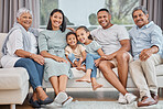 Happy and affectionate young mixed race family of six sitting on a sofa in the home living room. Married couple with their mother, father, son and daughter in the lounge. Granny and grandpa visit