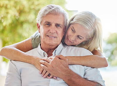 Buy stock photo A happy mature caucasian couple embracing and showing love while relaxing together at home. Retired couple bonding while sitting together