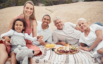 Buy stock photo Portrait, love and happy interracial family having a picnic on the beach and smile while having some food with snacks. Bonding on a day out at the beach on tropical vacation holiday in summer