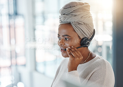 One happy african american call centre telemarketing agent talking on a headset while working in an office. Confident friendly female consultant operating a helpdesk for customer service and sales support