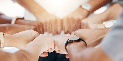 Closeup of diverse group of people making fists in a circle to express unity, support and solidarity. Hands of multiracial community greeting with fist bump in a huddle. Society joining together for collaboration and equality