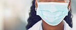 Closeup african american woman doctor wearing a mask while standing in the hospital. Being safe during the corona virus pandemic. Stop the spread of covid 19. Health and safety in the medical field