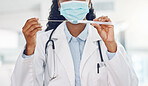 Closeup african american woman doctor wearing a mask and holding a swab test in the hospital. Testing for the corona virus pandemic. Stop the spread of covid 19 and get tested. Health and medicine