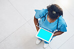 Above african american woman doctor using a digital tablet while standing and working in the office. Using wireless technology to diagnose and treat diseases in the field of health and medicine
