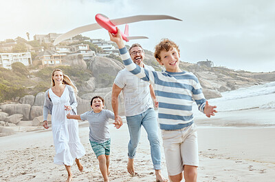 Buy stock photo Happy caucasian parents and kids playing with a toy plane while enjoying quality time on a relaxing fun family summer vacation together at the beach. Loving mom and dad bonding with cheerful sons